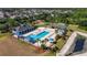 Aerial view of community pool, playground, and basketball court surrounded by palm trees in a residential neighborhood at 32628 Harmony Oaks Dr, Wesley Chapel, FL 33545