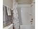 Shower with tub with marble shower curtain and gray towels, along with shower accessories at 32628 Harmony Oaks Dr, Wesley Chapel, FL 33545
