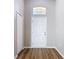 Welcoming foyer with a white front door, transom window, wood-look floors and neutral paint at 36144 Markree Castle Ave, Dade City, FL 33525