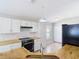 Bright kitchen features white cabinets, butcher block countertops, black appliances and tile backsplash at 36144 Markree Castle Ave, Dade City, FL 33525