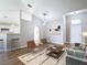 Bright living room featuring neutral paint, wood-look floors, high ceilings, and modern furnishings at 36144 Markree Castle Ave, Dade City, FL 33525
