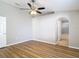 Open main bedroom with wood floors, fan, and archway to bathroom at 36144 Markree Castle Ave, Dade City, FL 33525