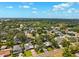 An aerial view showcases a neighborhood with lush trees and homes under a clear blue sky at 3914 W Cleveland St, Tampa, FL 33609