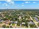 The aerial view captures a charming neighborhood with lush trees and clear blue skies above at 3914 W Cleveland St, Tampa, FL 33609