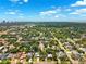 An aerial view showcases a neighborhood with lush treescapes and clear blue skies at 3914 W Cleveland St, Tampa, FL 33609