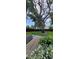 A backyard featuring a table and chairs, lush green grass, beautiful, mature trees, and manicured landscaping at 3914 W Cleveland St, Tampa, FL 33609