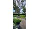 A backyard featuring a table and chairs, lush green grass, beautiful, mature trees, and manicured landscaping at 3914 W Cleveland St, Tampa, FL 33609