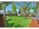 A beautifully landscaped backyard has a lush lawn, mature trees, a shed, and outdoor seating at 3914 W Cleveland St, Tampa, FL 33609