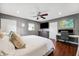 This spacious main bedroom is well lit with a ceiling fan, desk, television, and natural light at 3914 W Cleveland St, Tampa, FL 33609