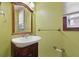 Cozy bathroom with a wood vanity, classic fixtures, and a mirror, exuding vintage charm at 4100 1St S Ave, St Petersburg, FL 33711