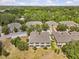 Rear aerial view of tan-colored townhomes, surrounded by green lawns and mature landscaping, creating a private setting at 4105 Bismarck Palm Dr, Tampa, FL 33610