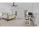 Bright bedroom featuring neutral decor, a ceiling fan, and a dedicated workspace by the windows at 4105 Bismarck Palm Dr, Tampa, FL 33610