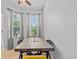 Dining room with a wooden table, modern chairs, and natural light streaming through the windows at 4105 Bismarck Palm Dr, Tampa, FL 33610