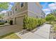 Side exterior of a two-story townhome featuring a two-car garage and lush landscaping at 4105 Bismarck Palm Dr, Tampa, FL 33610
