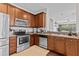 Well-lit kitchen featuring stainless steel appliances, granite countertops, and wooden cabinets at 4105 Bismarck Palm Dr, Tampa, FL 33610