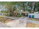 Charming yellow home featuring a covered carport, mature trees, and a well-maintained front yard at 4124 W San Juan St, Tampa, FL 33629