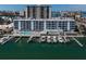 Stunning aerial of waterfront condo with boat slips, pool and bay views with buildings and landscaping at 415 Island Way # 511, Clearwater Beach, FL 33767