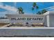 Island Estates entrance sign with palm trees, landscaping and blue sky in the background at 415 Island Way # 511, Clearwater Beach, FL 33767