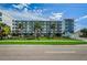 Modern condo building featuring well-kept landscaping, palm trees, and stylish architectural design at 415 Island Way # 511, Clearwater Beach, FL 33767