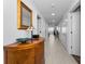 Bright hallway with wood cabinet, mirror, lamp and tile floor at 415 Island Way # 511, Clearwater Beach, FL 33767