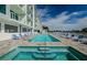 A pristine community pool surrounded by lounge chairs and a modern building exterior at 415 Island Way # 511, Clearwater Beach, FL 33767