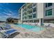 A refreshing community pool area with lounge chairs, set against a modern condo exterior at 415 Island Way # 511, Clearwater Beach, FL 33767