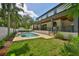 Expansive backyard featuring a sparkling pool, lush lawn, and covered patio at 4224 W Corona St, Tampa, FL 33629