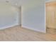 Bedroom featuring wood-look floors, neutral paint, recessed lighting, a white door, and an open bathroom at 4224 W Corona St, Tampa, FL 33629