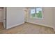 This bright bedroom has wood-look floors, white trim, a window, and an adjacent doorway at 4224 W Corona St, Tampa, FL 33629