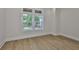 A bedroom with new hardwood flooring has bright natural light from the large double-hung window at 4224 W Corona St, Tampa, FL 33629
