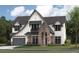 Charming two-story home with stone archway, grey roof, grey garage door, and well-manicured lawn at 4224 W Corona St, Tampa, FL 33629