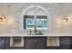 Elegant kitchen with a stone backsplash, stainless steel appliances, dark cabinetry and a view of the lush surroundings at 4224 W Corona St, Tampa, FL 33629