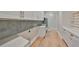 Bright laundry room with white cabinetry, sleek hardware and tiled backsplash at 4224 W Corona St, Tampa, FL 33629