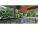 Outdoor kitchen features stainless steel appliances, dark countertops, and a wood ceiling at 4224 W Corona St, Tampa, FL 33629