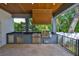 Outdoor kitchen with stainless steel appliances, granite countertops, and wood ceiling at 4224 W Corona St, Tampa, FL 33629