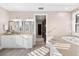 Bright bathroom with a double vanity, soaking tub and neutral finishes at 429 St Andrews Dr, Belleair, FL 33756