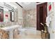 This bathroom features marble tile throughout, a large mirror, and a pedestal sink at 429 St Andrews Dr, Belleair, FL 33756
