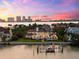 Waterfront home with a private boat dock and lift overlooking the water at sunset at 429 St Andrews Dr, Belleair, FL 33756