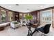 This is a second view of the office, it features large windows and two cream-colored chairs with teal throw pillows at 429 St Andrews Dr, Belleair, FL 33756