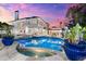 Twilight view of home's luxurious pool, spa, and meticulously landscaped backyard at 429 St Andrews Dr, Belleair, FL 33756
