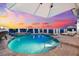 Beautiful pool with baja shelf under an umbrella, providing a perfect spot to relax at 429 St Andrews Dr, Belleair, FL 33756