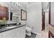 Stylish powder room with modern fixtures, dark granite countertop and new fixtures at 429 St Andrews Dr, Belleair, FL 33756