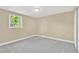 A cozy bedroom features neutral walls, gray carpet and a bright window at 4304 W Arch St, Tampa, FL 33607