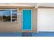 A charming teal front door with brick facade and a 