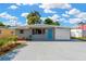 Charming single-story home featuring a light blue door, attached garage, and well-maintained landscaping at 4304 W Arch St, Tampa, FL 33607