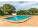 Community swimming pool surrounded by a brick patio and trees, offering a relaxing oasis for residents at 4306 La Mora Ct, Tampa, FL 33611