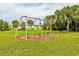 Colorful playground with swings set in a well-maintained, grassy area, surrounded by shady trees at 4306 La Mora Ct, Tampa, FL 33611