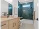 Bathroom with emerald green tiled wall over tub, blond wood vanity, and black fixtures at 500 E Davis Blvd, Tampa, FL 33606
