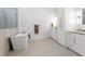 Bright and airy main bathroom featuring a standalone tub, glass-enclosed shower, double vanity and plenty of storage at 500 E Davis Blvd, Tampa, FL 33606