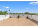 Spacious roof deck with neutral flooring, perimeter wall, potted plants, and distant views of mature trees and a blue sky at 500 E Davis Blvd, Tampa, FL 33606